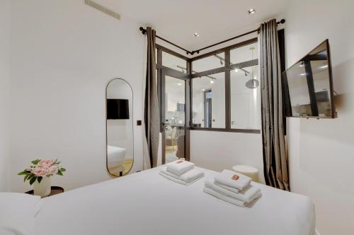 巴黎的住宿－CMG Lamartine-Maubeuge，卧室配有白色的床和大镜子