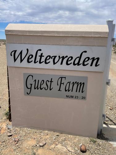 ein Schild für einen Bauernhof auf einem Gebäude in der Unterkunft Weltevreden Guest Farm in Klavervlei