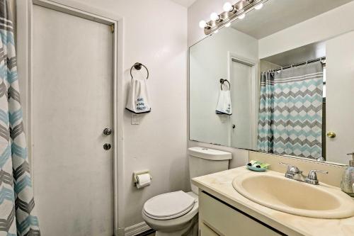a bathroom with a sink and a toilet and a mirror at Kissimmee Home with Game Room, 7 Mi to Disney Parks! in Orlando