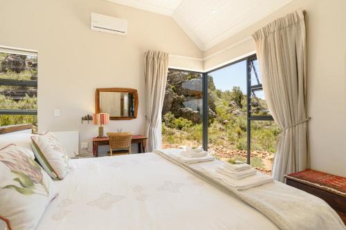 a bedroom with a bed and a large window at Fynbosrust in Wolseley
