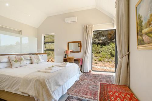 a bedroom with a bed and a large window at Fynbosrust in Wolseley