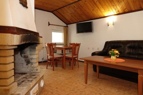 a living room with a fireplace and a table at Семеен хотел Орфей in Teshel