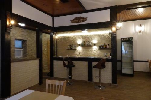 a bar in a restaurant with a brick wall at Семеен хотел Орфей in Teshel