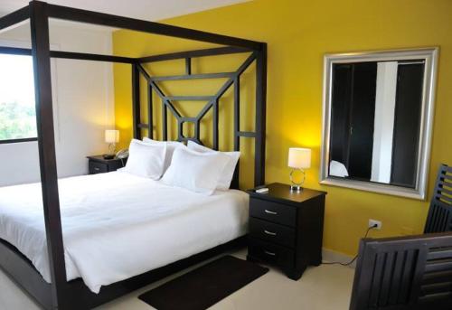a bedroom with a large white bed and a window at Wayak Hotel in Managua