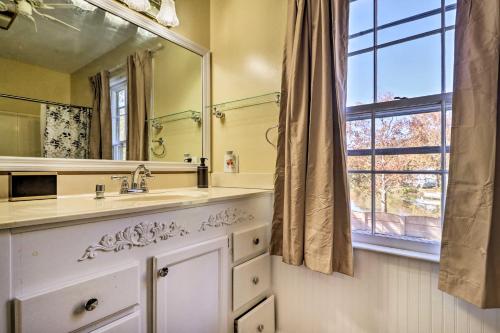 a bathroom with a sink and a large mirror at Lakefront Macon Home with Pool, Dock and Fire Pit! in Macon