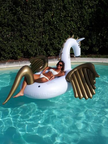 una mujer está montando en una balsa de unicornio en una piscina en Two Elegant Depandance en Conscio