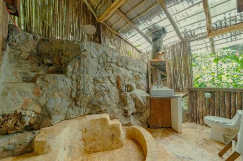 a stone bathroom with a sink and a toilet at El Valle Lodge in El Valle