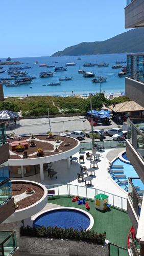 a view of a resort with boats in the water at apartamento de frente para o mar com linda area de lazer in Arraial do Cabo