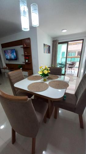 a dining room with a white table and chairs at apartamento de frente para o mar com linda area de lazer in Arraial do Cabo
