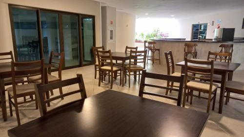 a restaurant with wooden tables and chairs and a bar at apartamento de frente para o mar com linda area de lazer in Arraial do Cabo