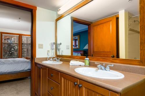 une salle de bains avec deux lavabos et un grand miroir dans l'établissement Eagle Springs East 302: Boxelder Suite, à Solitude