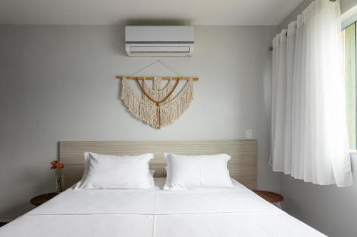 a bedroom with a large white bed with white pillows at Pousada Casa da Praia Angra in Angra dos Reis