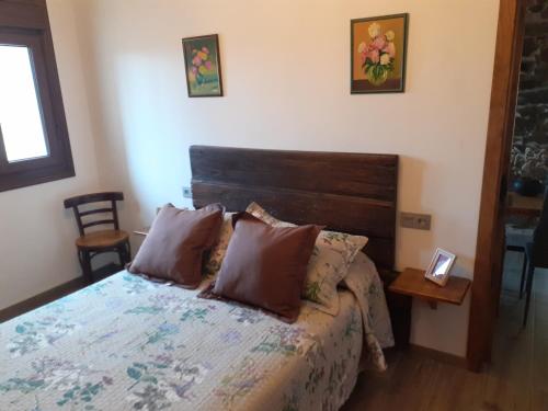 a bedroom with a bed with a wooden headboard at A Nosa Casa 2 in Belesar