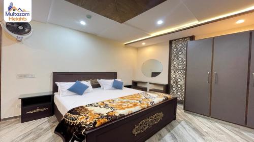 1 dormitorio con 1 cama grande en una habitación en Multazam Heights, DHA Phase 8 - Three Bedrooms Family Apartments, en Lahore