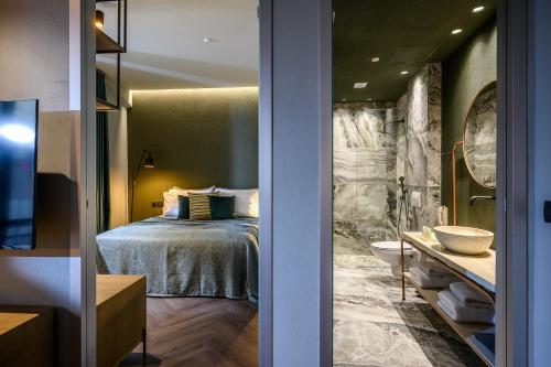 - une chambre avec un lit et une salle de bains pourvue d'un lavabo dans l'établissement Pagopoieion - Adults Only Suites, à Héraklion