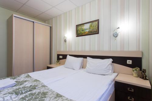 a bedroom with a bed with white sheets and pillows at Hotel Voyage in Kharkiv