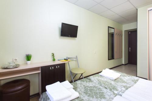 a hotel room with a bed and a tv on the wall at Hotel Voyage in Kharkiv