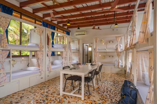 a room with a table and chairs and bunk beds at Moustache Goa Luxuria in Vagator