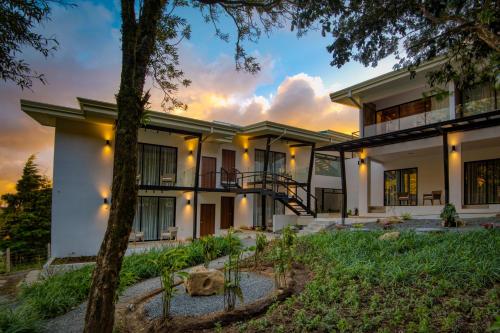 an exterior view of a house with a tree at Ocotea Boutique Hotel in Monteverde Costa Rica