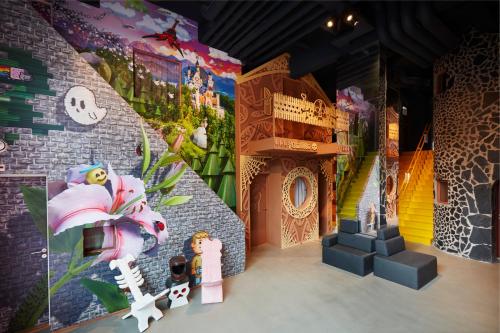 Cette chambre est dotée d'un mur en briques et d'un mur orné de peintures. dans l'établissement Hotel Not Hotel Rotterdam, à Rotterdam