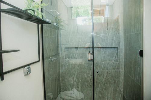 een douche met een glazen deur in de badkamer bij Pousada Saint Diniz in Monte Sião