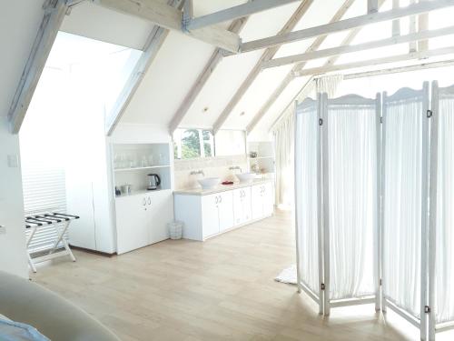 a kitchen with white cabinets and a large window at Whales Way Ocean Retreat in Wilderness