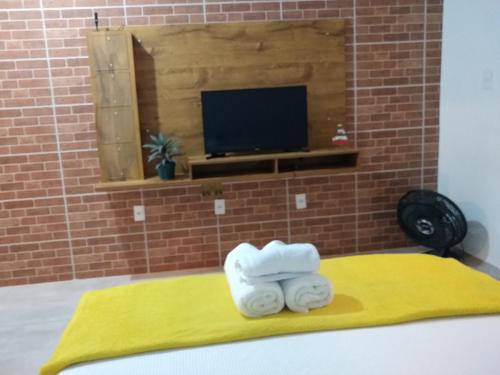 dois rolos de toalhas sentados em cima de uma cama em Aconchego Standart em Angra dos Reis