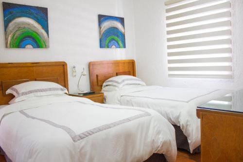 two beds in a room with white sheets at Finca del Rocio in Parras de la Fuente