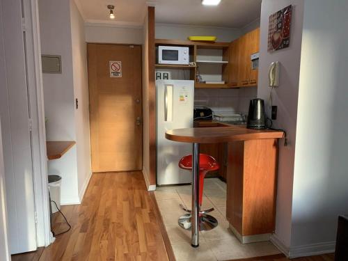 a small kitchen with a table and a refrigerator at Depto Metro Plaza de Armas (1 dormitorio 1 baño) in Santiago