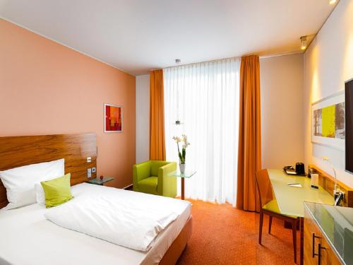 a hotel room with a bed and a desk and a room at Schlosshotel Hellenstein in Heidenheim