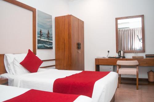 a hotel room with two beds and a desk at Tarshish Villa - Colombo in Colombo