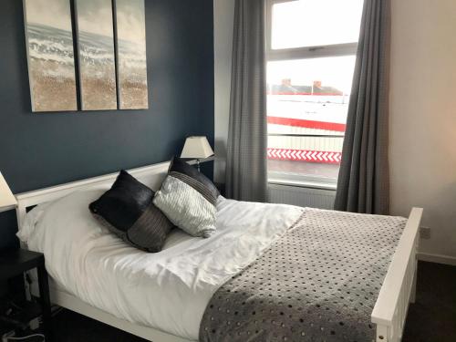 a bedroom with a bed with pillows and a window at 3 Bedroom House Close to M6 & M55 in Preston