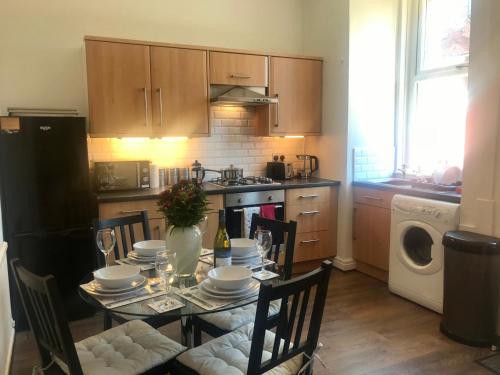 a kitchen with a table with chairs and a dining room at 3 Bedroom House Close to M6 & M55 in Preston
