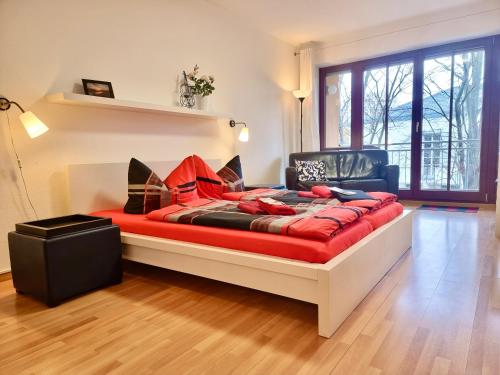 a bedroom with a bed with a red blanket at FeWo 2,4,5,6 Altstadt - Am grossen Garten in Dresden