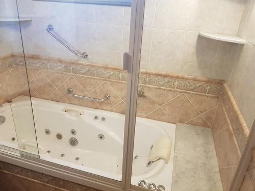 y baño con bañera y puerta de ducha acristalada. en La Deolinda en Funes