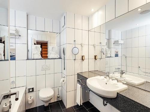 a white bathroom with a sink and a toilet at Schlosshotel Hellenstein in Heidenheim