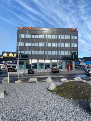 ein Hotelgebäude mit auf einem Parkplatz geparkt in der Unterkunft HHE Express in Nuuk