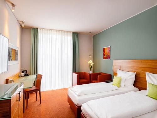 a hotel room with two beds and a desk at Schlosshotel Hellenstein in Heidenheim