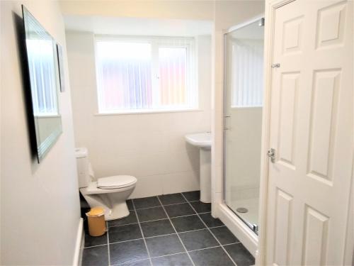 a bathroom with a toilet and a sink at Modern comfy 2-Bedroom flat in St Helens in Saint Helens
