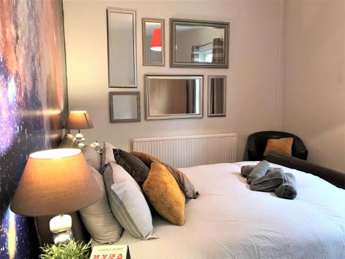 Un dormitorio con una cama con almohadas. en Central Wigan welcoming Townhouse sleeps up to 6, en Wigan