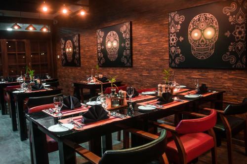a restaurant with black tables and red chairs and skulls on the walls at Tarshish Villa - Colombo in Colombo