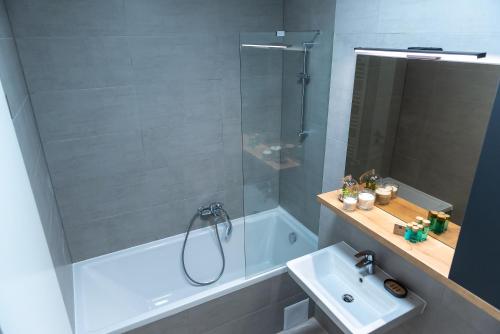 a bathroom with a tub and a sink and a shower at Apart B&V in Braşov