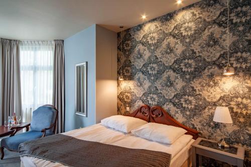 a bedroom with a bed with a floral wallpaper at Monaco Ville in Międzyzdroje