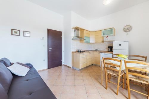 a living room with a table and a kitchen at Vila Bicikleta Istra in Peroj