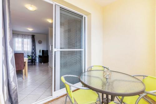 a dining room with a glass table and yellow chairs at Vila Bicikleta Istra in Peroj