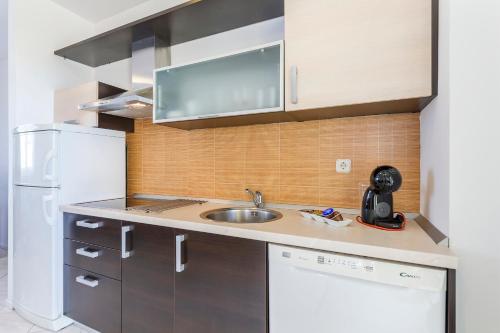a small kitchen with a sink and a refrigerator at Vila Bicikleta Istra in Peroj