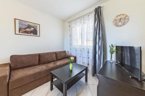 a living room with a couch and a tv at Vila Bicikleta Istra in Peroj