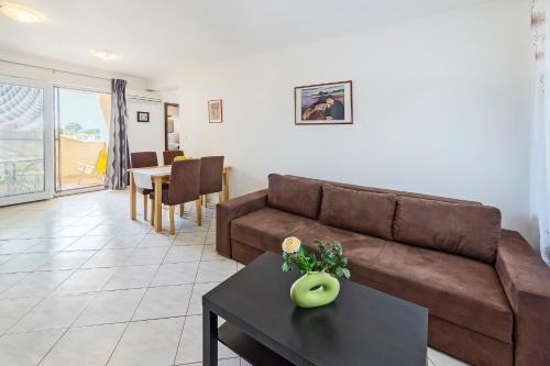 a living room with a brown couch and a table at Vila Bicikleta Istra in Peroj