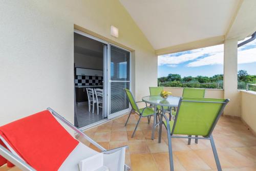 a balcony with a table and chairs in a room at Vila Bicikleta Istra in Peroj