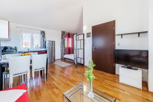 a kitchen and living room with a table and a television at Vila Bicikleta Istra in Peroj